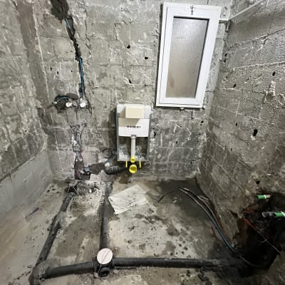 צנרת מים וביוב מותקנת בקיר בטון חשוף