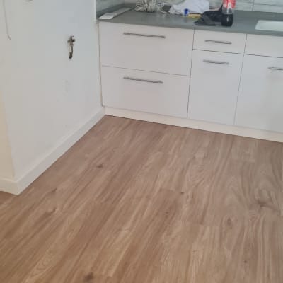 רצפת פרקט עץ בהירה במטבח עם כיסא פלסטיק