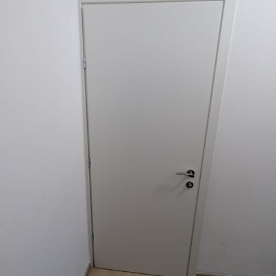 דלת לבנה בחדר עם רצפת עץ