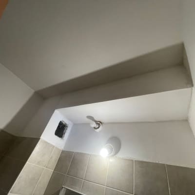 קיר גבס עם מנורה ותקרה משופעת