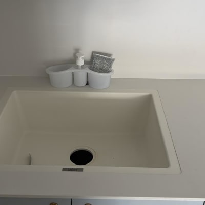 כיור לבן עם מתקן לסבון ומטלית