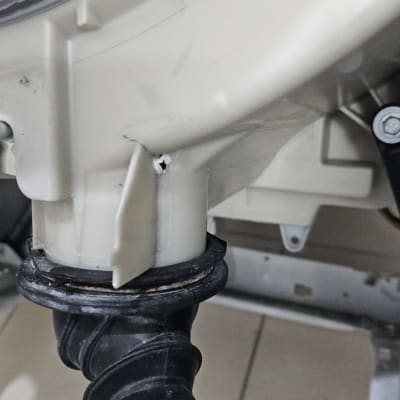 חלק ממכונת כביסה עם צינור גומי וחיבורים