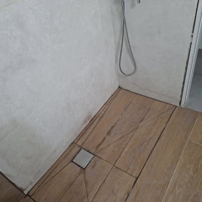רצפת מקלחת עם אריחים ומקלחת יד