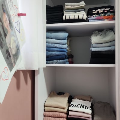 בגדים מקופלים בארון לבן עם מדפים