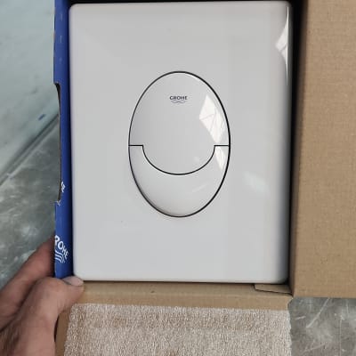 לחצן הדחה לבן של גרואה באריזה