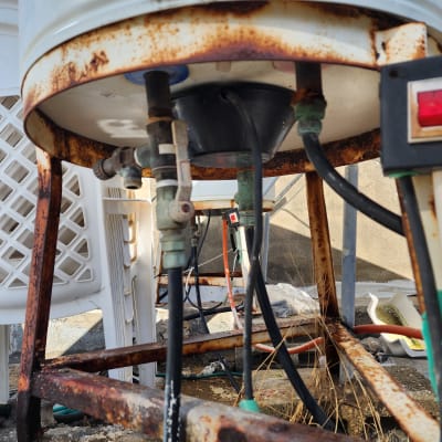 חוטי חשמל מחוברים לדוד מים חלוד על גג