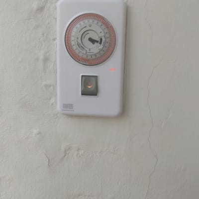 טיימר חשמלי מותקן על קיר לבן