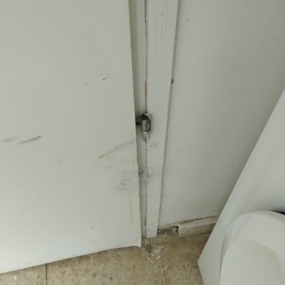 דלת לבנה עם מנעול בריח מתכת בתחתית