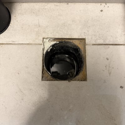 פתח ניקוז ברצפה עם צינור שחור