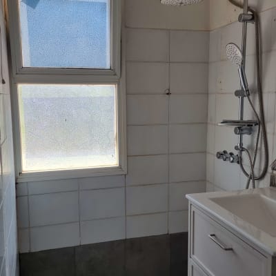 מקלחת עם אריחים לבנים וברזים