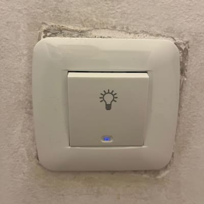 מתג חשמל עם סמל נורה על קיר