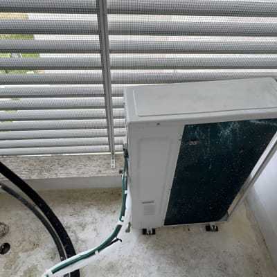 יחידת מיזוג אוויר מלוכלכת ליד חלון עם תריסים