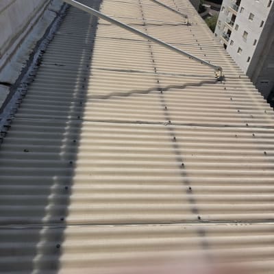גג בניין עם קורות מתכת ותקרה גלי