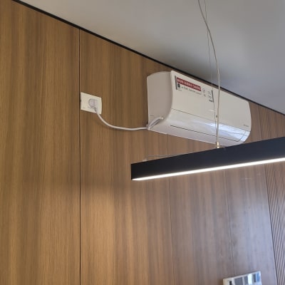 מזגן מותקן על קיר עץ עם חוט חשמל מחובר