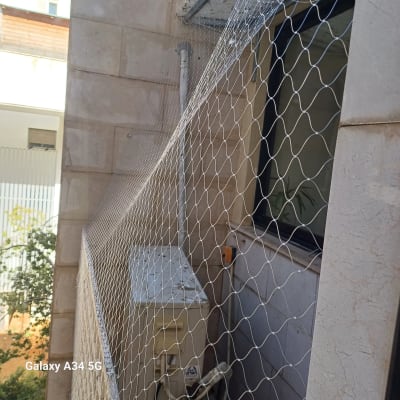 רשת יונים מותקנת על חלון בניין