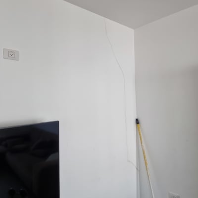 קיר עם סדק ומוט צביעה בפינה