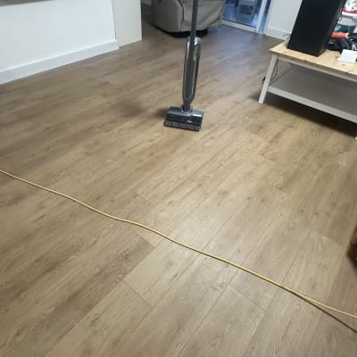 רצפת עץ עם שואב אבק בחדר מגורים