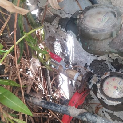 ברז מים עם ידית אדומה ומד מים ישן