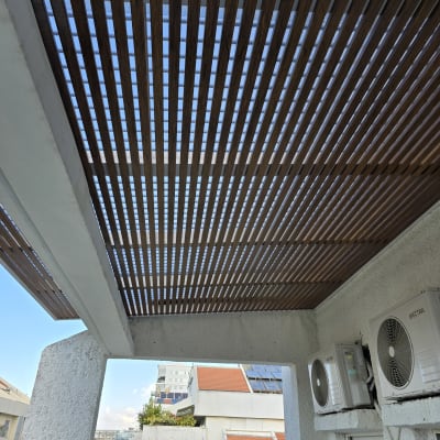 פרגולה מאלומיניום עם קורות עץ מעל מרפסת