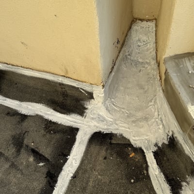 איטום פינות עם חומר לבן על רצפה כהה