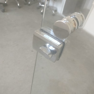 ידית מתכת על דלת זכוכית שקופה