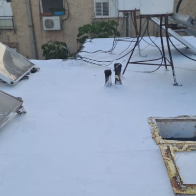 גג אטום עם חומר איטום לבן, צינורות ואנטנות