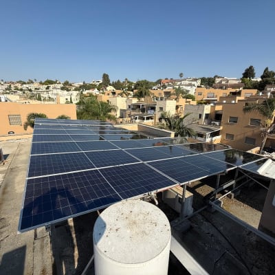פאנלים סולאריים על גג עם נוף עירוני ברקע