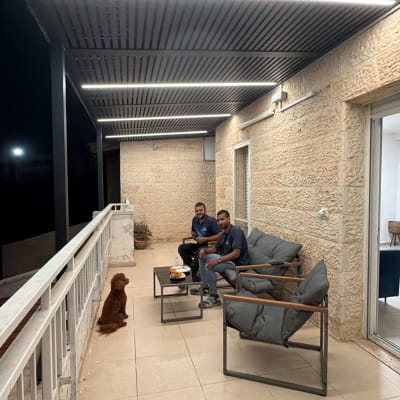 מרפסת עם פרגולה אלומיניום ושני אנשים יושבים