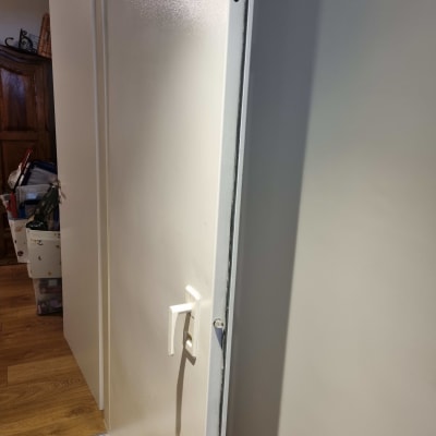 דלת לבנה עם ידית פתוחה חלקית