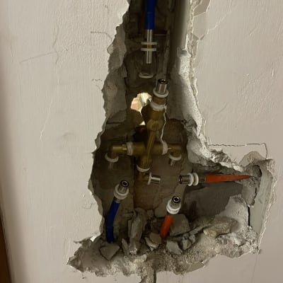 צנרת מים חשופה בקיר עם חיבורים