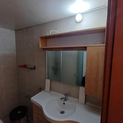 חדר אמבטיה עם מדף עץ מעל מראה