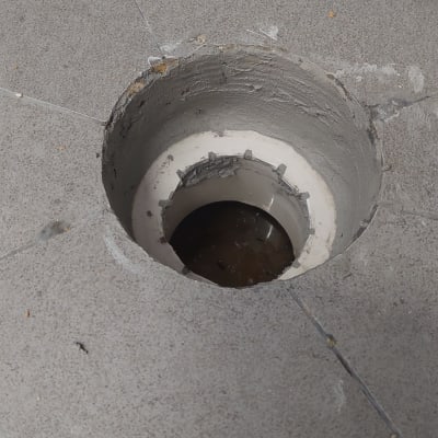 חור ברצפה עם צינור ביוב חשוף
