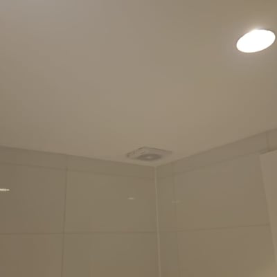 תקרת חדר עם פתח אוורור ומנורות שקועות