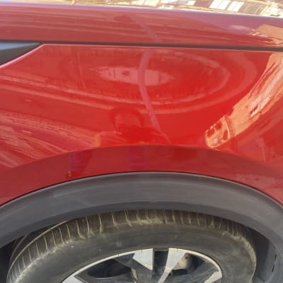 צבע אדום מבריק על כנף רכב עם צמיג