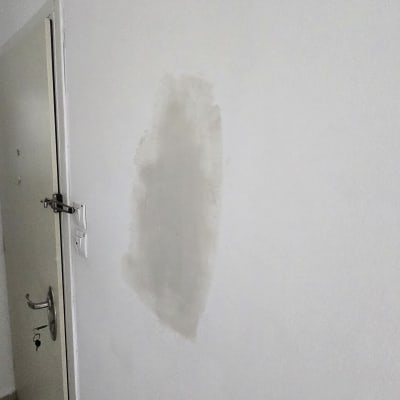 תיקון שפכטל מקומי על קיר לבן מעל משקוף דלת