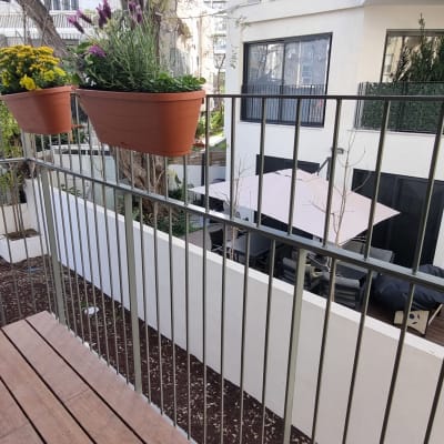 מעקה מתכת עם עציצים תלויים במרפסת