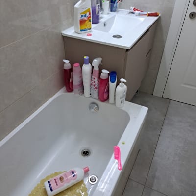 אמבטיה עם בקבוקי שמפו ומסרק ורוד