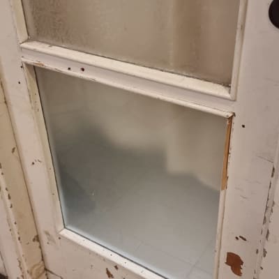 דלת עם זכוכית חלבית ושקופה במסגרת עץ מתקלפת