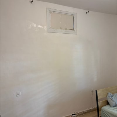 קיר צבוע עם חלון קטן בחדר