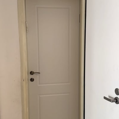 דלת לבנה עם ידית מתכת כסופה פתוחה חלקית