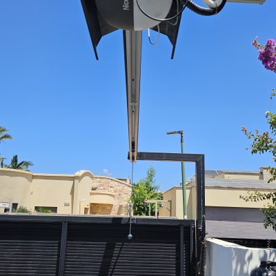 שער חשמלי עם מנגנון פתיחה Nice Spido בשמים כחולים