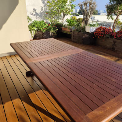 שולחן עץ על דק עם עציצים מסביב