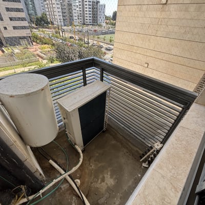 מרפסת עם רשת למניעת כניסת יונים, מזגן ודוד שמש