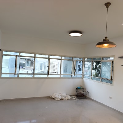 חדר צבוע עם חלונות פתוחים ותאורה תלויה