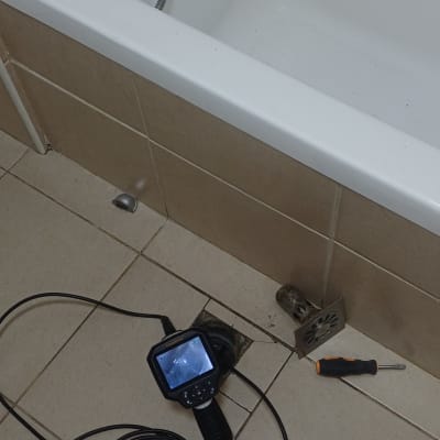 כלי עבודה וצנרת ליד אמבטיה