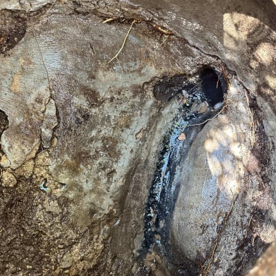 בור עם צינור מים דולף ואדמה רטובה