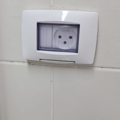 שקע חשמלי עם כיסוי פלסטיק לבן על קיר