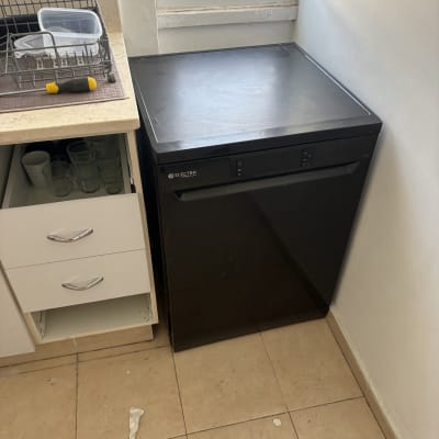 מדיח כלים ליד כיור במטבח עם כלים