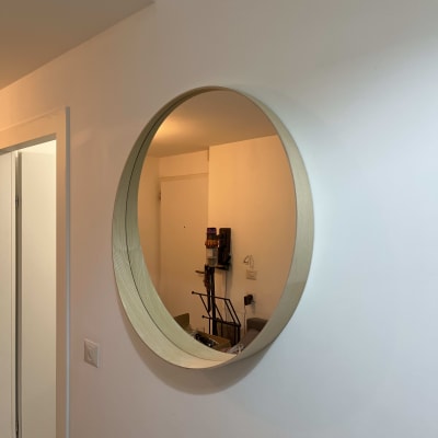 שואב אבק תלוי על הקיר ליד מראה עגולה