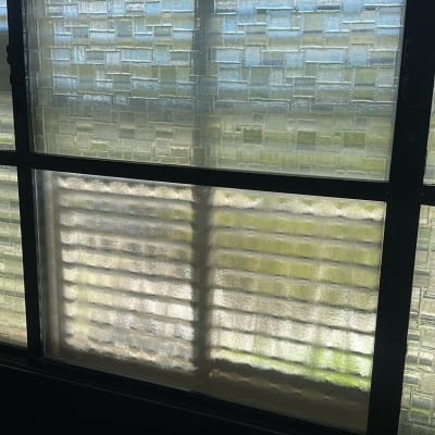 חלון זכוכית עם דוגמה מרובעת ואור שמש